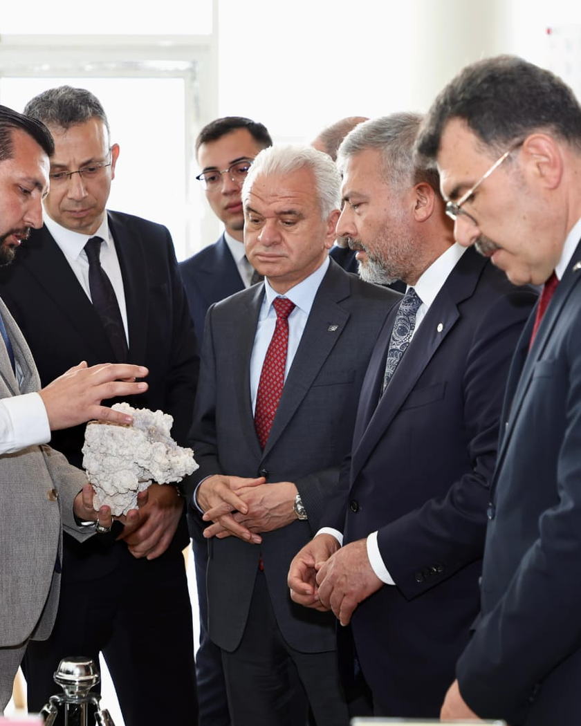 Elinde beyaz bir lületaşı yumrusu tutan bir kişi, karşısındaki gruba malzemeyi anlatırken.